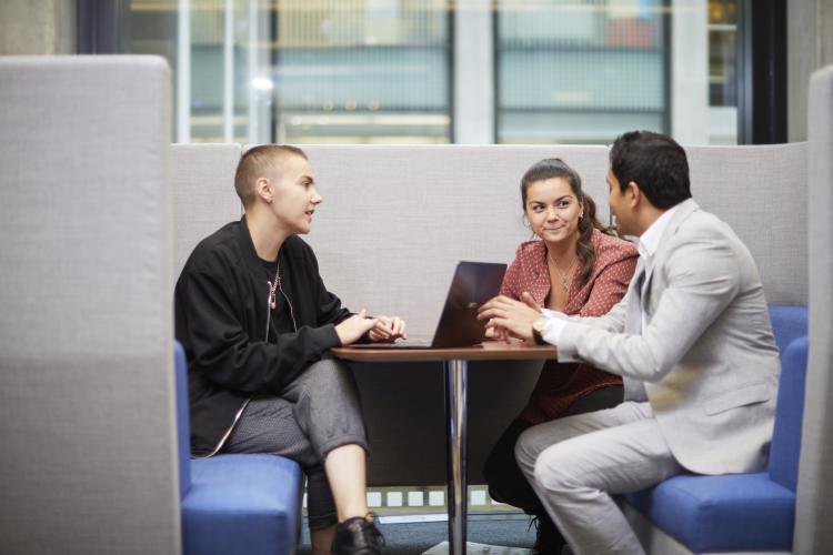 Three people sitting in a business meeting