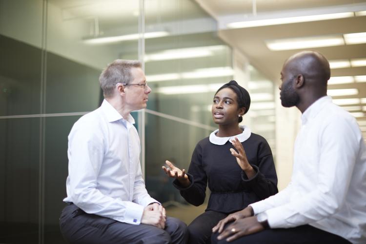 Three people sitting in a business meeting