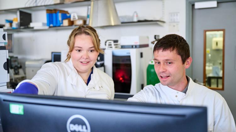 Two scientists looking at a monitor