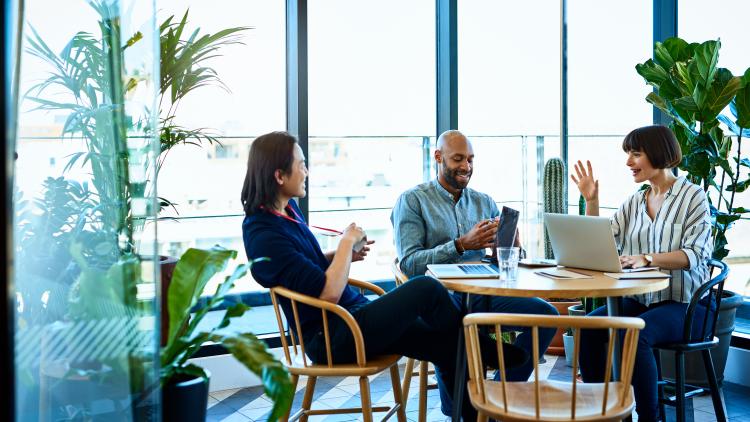 Three people in discussion sat at a table