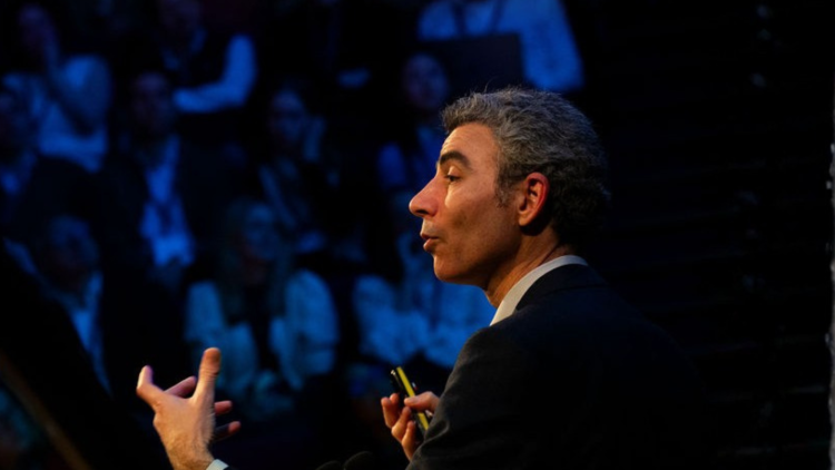 Nitzan Rosenfeld gestures during his keynote at the Innovation Summit 2025. 