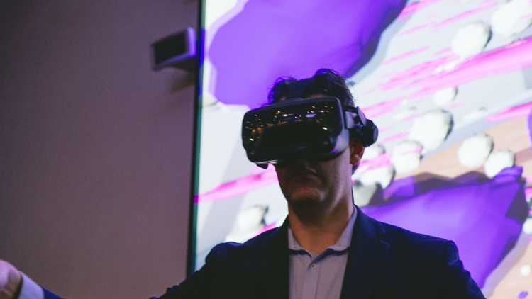 Man with VR goggles on in front of a screen