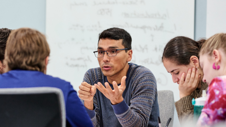 A group of researchers talk in a conference room. 