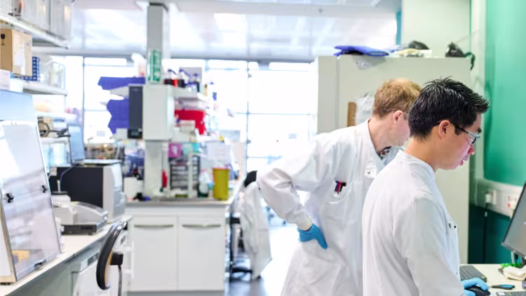 Two scientists in a lab looking at results on a screen