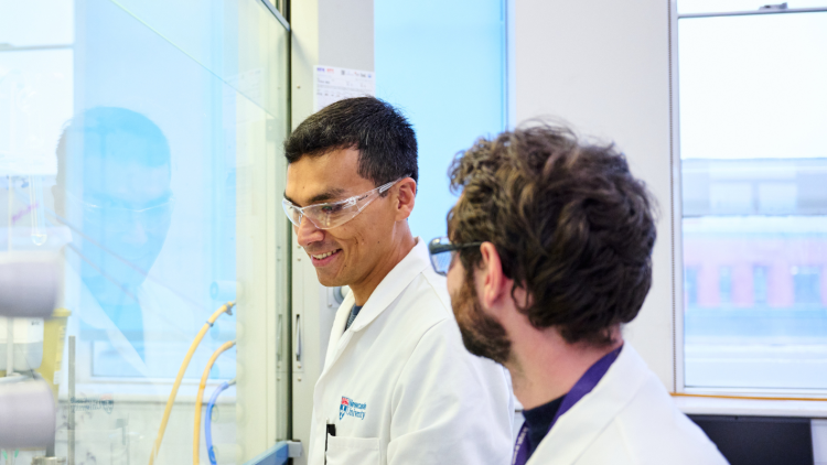 Two scientists speaking together in a lab