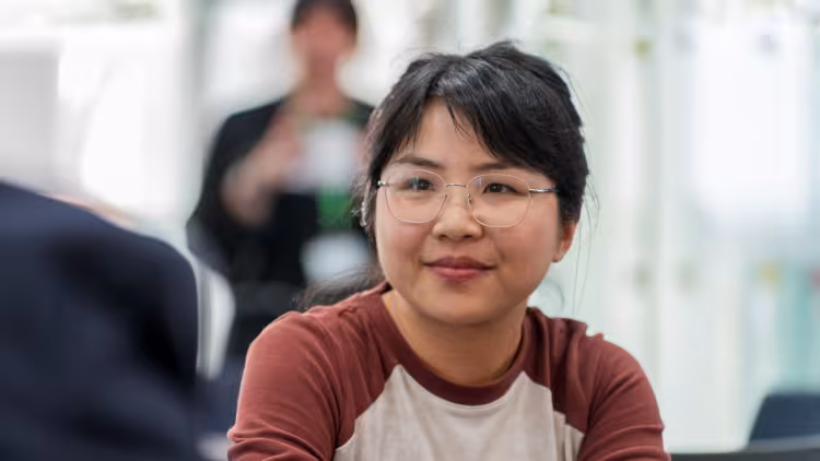 A young scientist wearing glasses and a red and white top