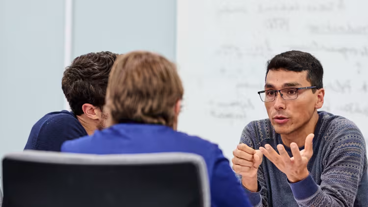 A group of researchers talk in a conference room. 