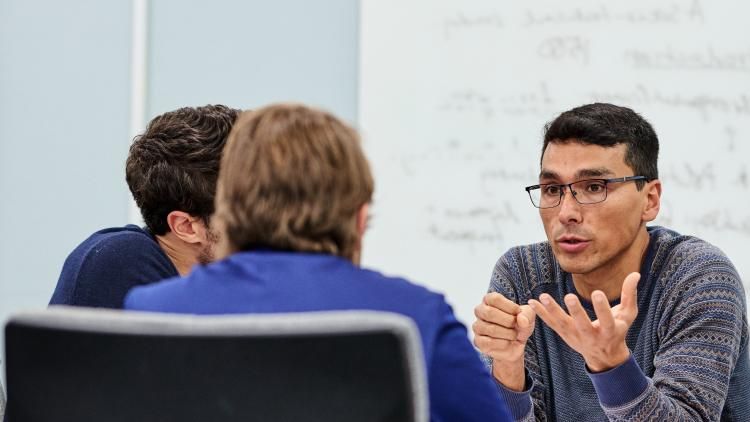 A group of researchers talk in a conference room. 