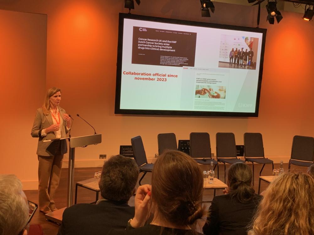 Anke Hövels delivering a presentation on KWF's partnership with the CDD to a crowded room.