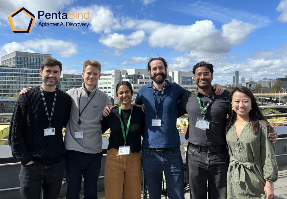 Six people standing together on a roof terrace.