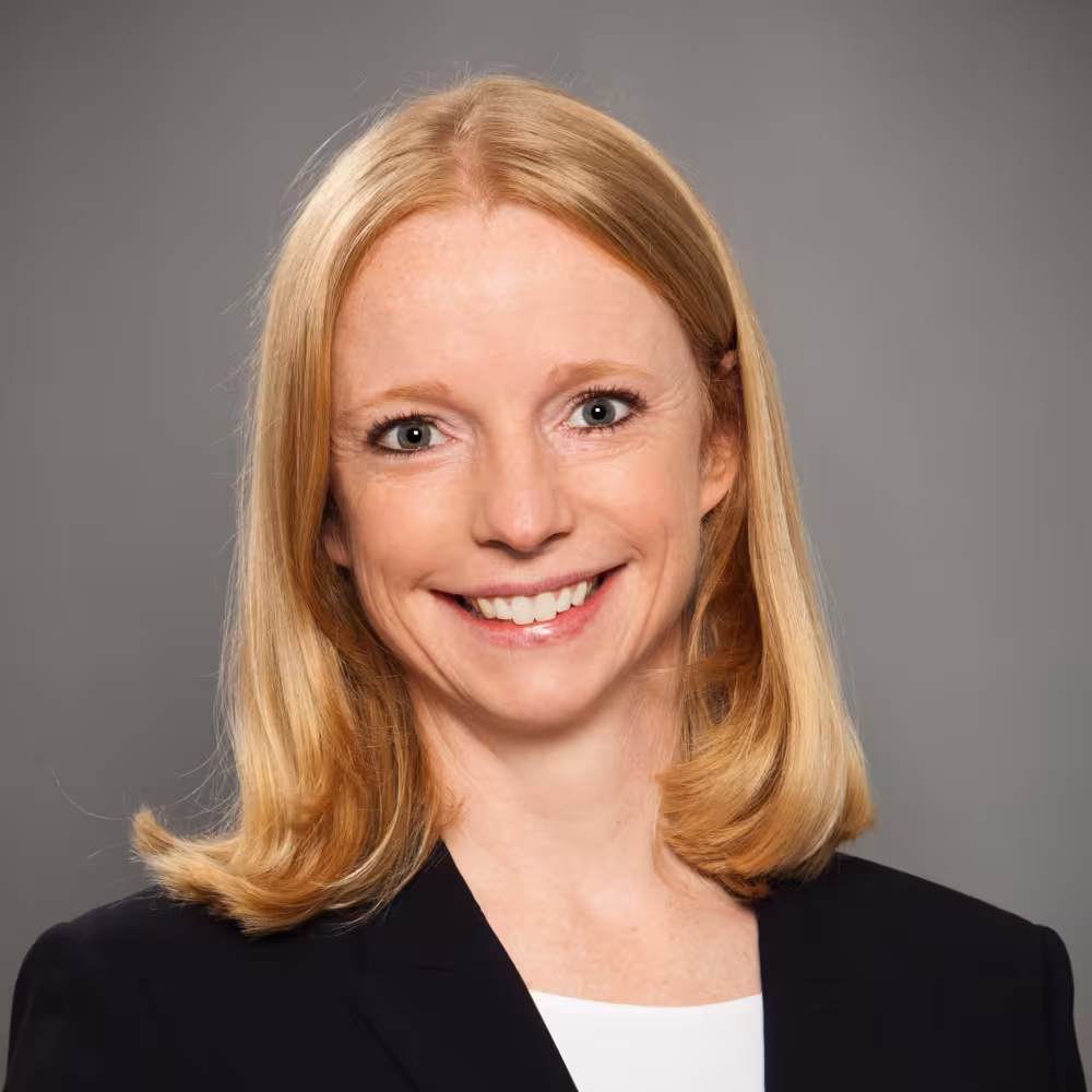A woman in a blazer smiling