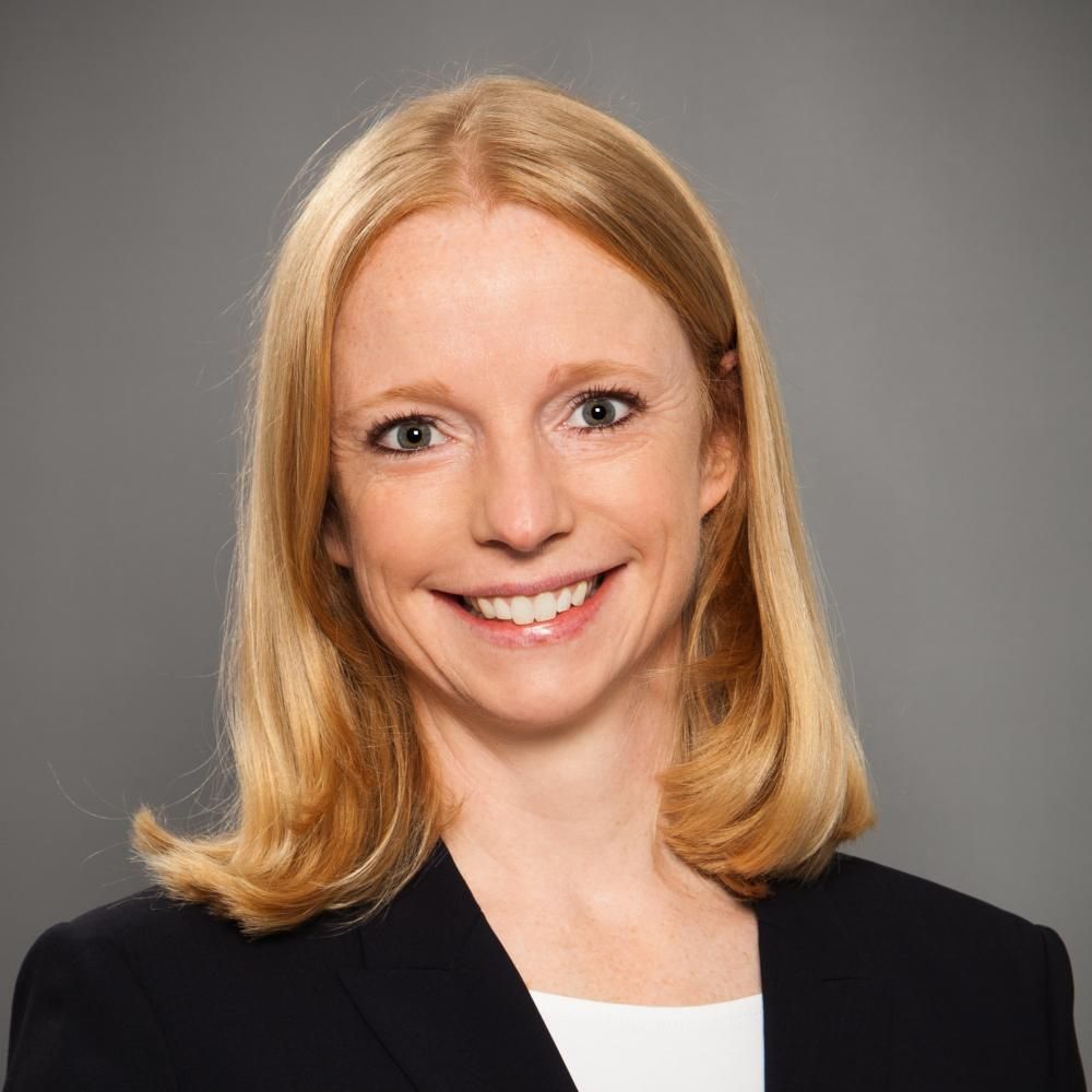 A woman in a blazer smiling