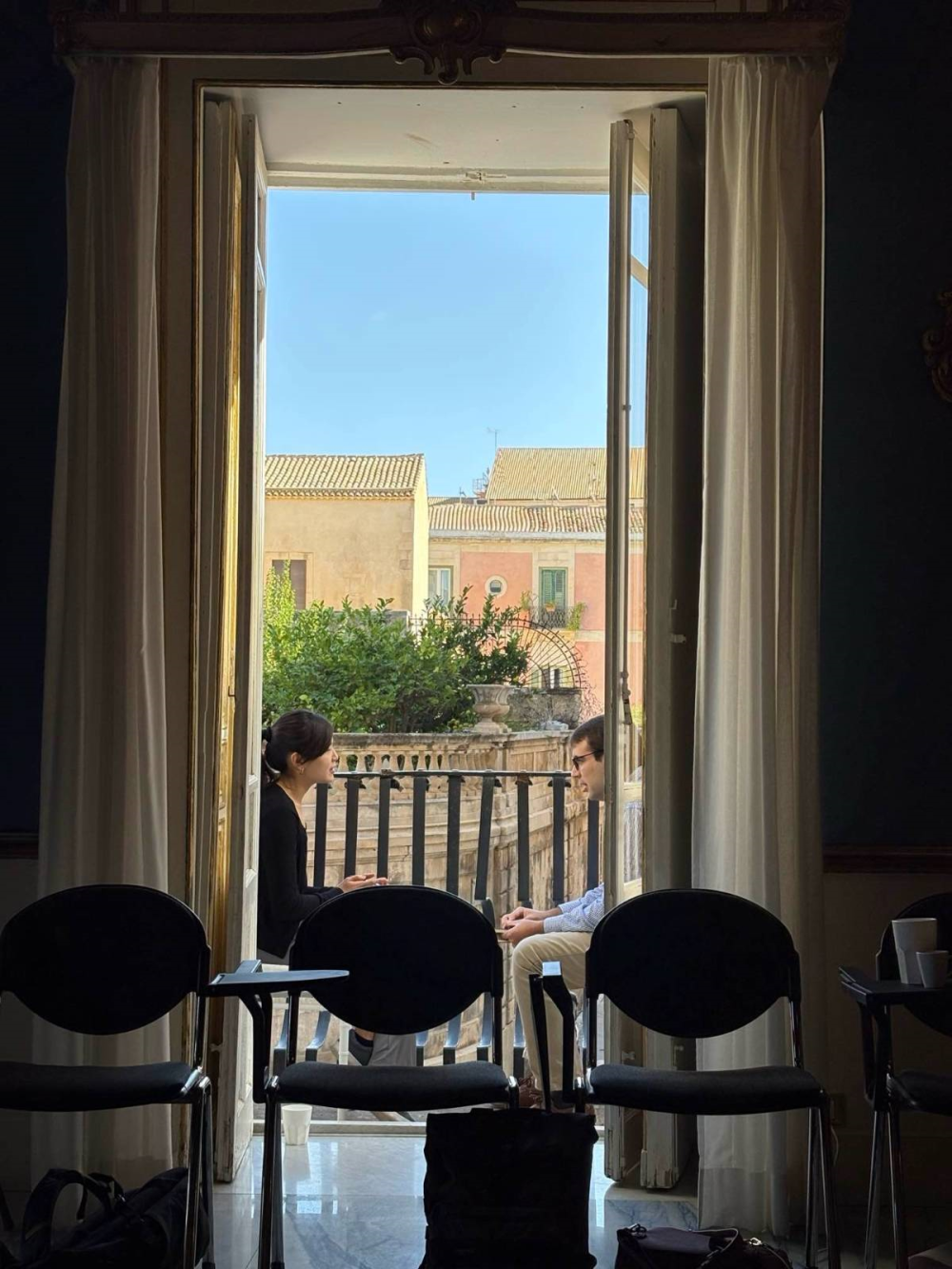 Two people sit on a balcony for a one-to-one speed consultancy session at the Eureka Institute's International Certificate Course in Translational Medicine